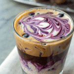 A creamy blueberry latte in glasse cup