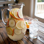 glasses of white peach sangria garnished with peach